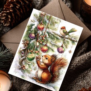May include: A watercolor Christmas card featuring a squirrel reaching for a Christmas ornament on a snow-covered pine branch. A small bird perches nearby. The card has red, green, and purple ornaments. The background includes a pine cone and a lit candle.