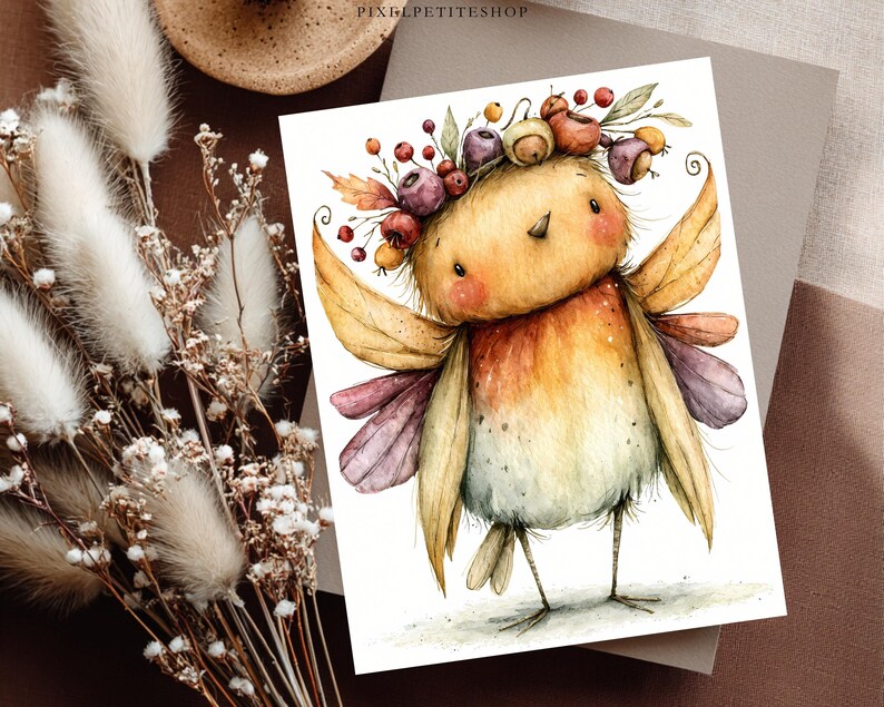May include: A watercolor illustration of a small, round bird with yellow and orange feathers, wearing a crown of autumn berries and leaves. The bird has small wings, thin legs, and a soft, speckled texture. The text PIXELPETITESHOP is visible.