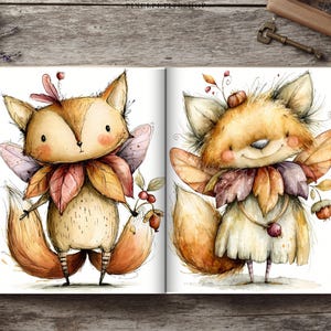 May include: An open book displaying two watercolor illustrations of anthropomorphic foxes with fairy wings. The foxes are adorned with autumn leaves, berries, and small acorns. Each fox has a fluffy tail, rosy cheeks, and striped leg details.