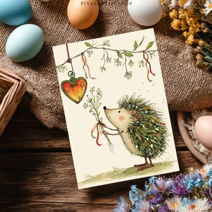 K&ouml;nnte beinhalten: Eine Gru&szlig;karte mit einer Aquarellillustration eines Igels, der Blumen h&auml;lt. Der Igel hat gr&uuml;ne und wei&szlig;e Stacheln und rote F&uuml;&szlig;e. Ein herzf&ouml;rmiges Ornament h&auml;ngt an einem Ast. Ostereier und Blumen umgeben die Karte.