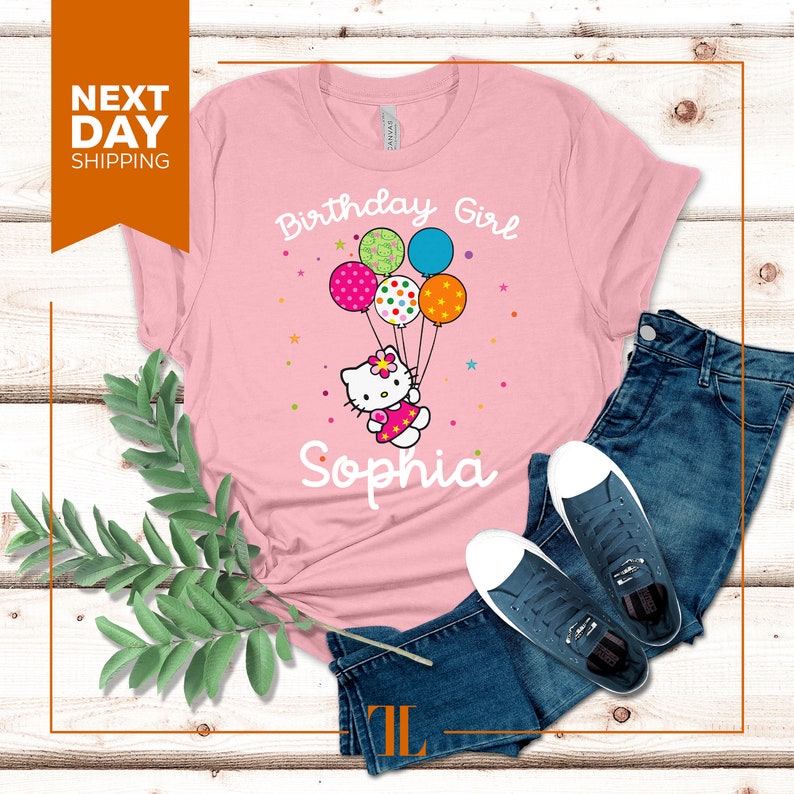 Puede incluir: Camiseta rosa con un gr&aacute;fico de Hello Kitty sosteniendo globos que dicen "Birthday Girl" y "Sophia".
