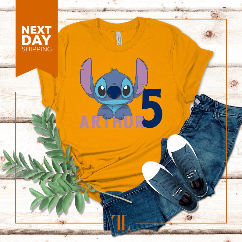 May include: A yellow t-shirt with a blue Stitch character from Lilo & Stitch, the number 5, and the name Arthur in purple letters.