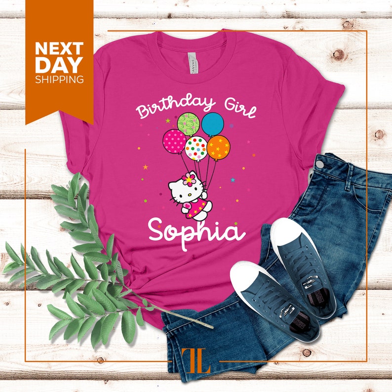 Puede incluir: Camiseta rosa con un personaje de Hello Kitty sosteniendo globos que dicen "Birthday Girl" y el nombre "Sophia".