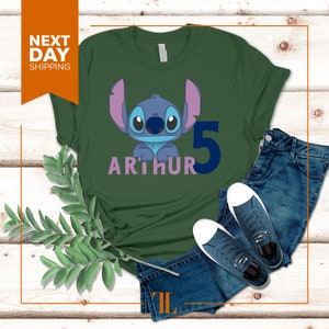 May include: Green t-shirt with a blue Stitch character from Lilo & Stitch, a pink "ARTHUR" and a blue "5" on the front.