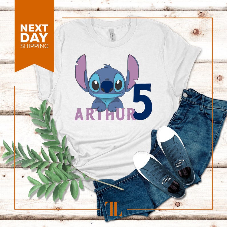 May include: White t-shirt with a blue Stitch character from Lilo & Stitch, the number 5, and the name Arthur in purple.