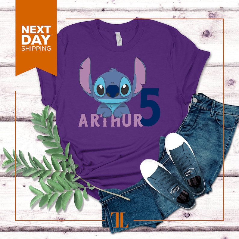 May include: Purple t-shirt with a blue Stitch character from Lilo & Stitch, the number 5, and the name Arthur in pink.