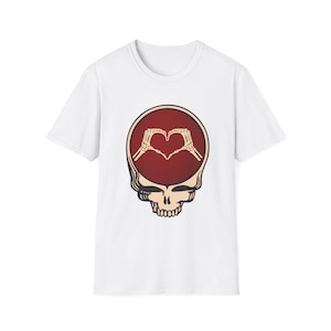 May include: White t-shirt featuring a skull design with a burgundy-colored head and a heart made of skeleton hands. The design is centered on the front of the shirt, offering a unique and eye-catching graphic.