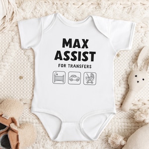 Może przedstawiać: Biały śpioszek dla niemowlęcia z czarnym napisem "Max Assist for Transfers" i trzema ikonami: ł&oacute;żeczkiem, samochodem i w&oacute;zkiem.
