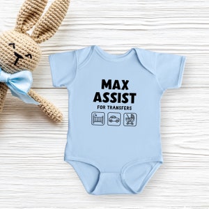 Może przedstawiać: Jasno niebieski śpioszek dla niemowlęcia z napisem "Max Assist for Transfers" i ikonami ł&oacute;żeczka, samochodu i w&oacute;zka.