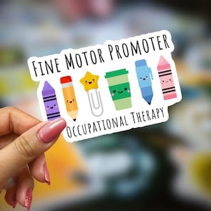 May include: White sticker with the text "Fine Motor Promoter Occupational Therapy" and a row of colorful cartoon characters including a purple crayon, a yellow pencil, a gold star with a paperclip, a green coffee cup, a blue pen, and a pink crayon.