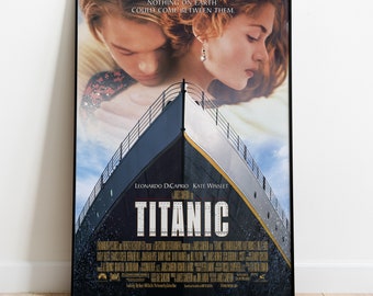 May include: A framed movie poster for Titanic featuring the bow of the ship rising against a blue sky. Above the ship, Leonardo DiCaprio and Kate Winslet are shown in an embrace. The text reads: NOTHING ON EARTH COULD COME BETWEEN THEM.