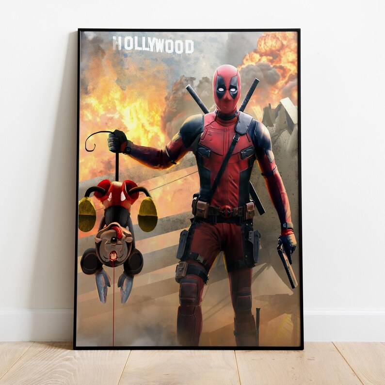 Puede incluir: P&oacute;ster enmarcado que muestra a Deadpool con un traje rojo y negro, sosteniendo un personaje de dibujos animados boca abajo. El fondo muestra una explosi&oacute;n de fuego y la palabra "HOLLYWOOD". Deadpool est&aacute; armado con espadas y una pistola.