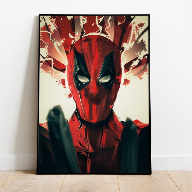 Puede incluir: Una impresi&oacute;n art&iacute;stica enmarcada con Deadpool. La obra de arte representa la cara de Deadpool con una m&aacute;scara roja y negra, con ojos blancos y un fondo rojo y blanco. El personaje sostiene dos pistolas negras, con un marco negro.