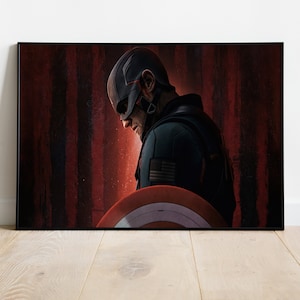 Puede incluir: Un superh&eacute;roe con un traje azul oscuro y rojo con un escudo rojo, blanco y azul se encuentra frente a un fondo de rayas rojas y negras. El superh&eacute;roe mira hacia abajo y parece estar en un estado de &aacute;nimo contemplativo.