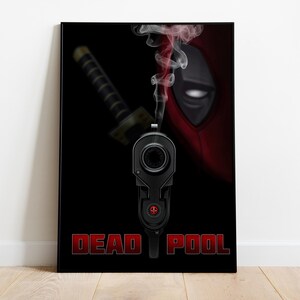 Puede incluir: Una impresi&oacute;n art&iacute;stica enmarcada que presenta una pistola negra con humo saliendo del ca&ntilde;&oacute;n. La m&aacute;scara de Deadpool es visible en el fondo, con una katana y las palabras "DEAD POOL" en rojo.