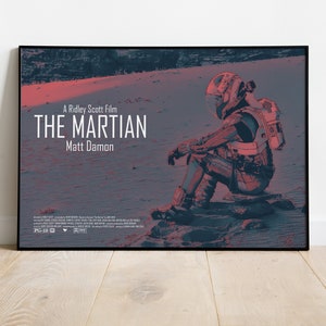 May include: A movie poster for the film "The Martian" featuring a red and blue color scheme. The poster features an astronaut sitting on a rocky surface with the title "The Martian" and the words "A Ridley Scott Film" and "Matt Damon" in white text.