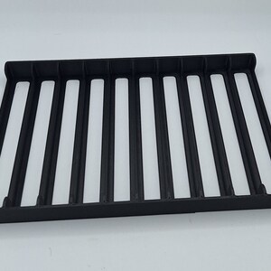 May include: Black plastic storage rack with 10 compartments. The rack is empty.