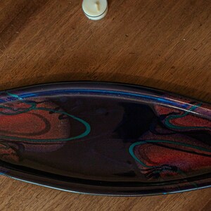 May include: A dark blue ceramic serving tray with a marbled design in shades of red, green, and black.