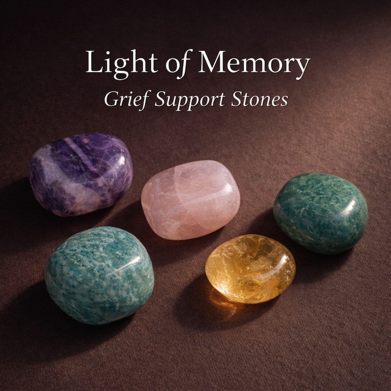 Grief support healing stones set informational cards from AuraBox displayed on a dark warm background with candlelight and dried flowers. The cards explain the meaning of Amethyst, Rose Quartz, Amazonite, Jade and Topaz crystals used for emotional healing, remembrance and comfort during loss. Memorial crystal gift set guide for sympathy, bereavement support and peaceful reflection.