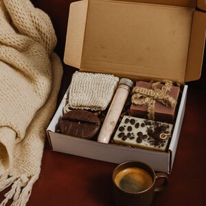 Coffee lover gift box featuring a handmade coffee scented candle and coffee inspired soap arranged in a cozy coffee themed gift box. This handmade coffee gift box is designed for coffee lovers and works as a unique coffee themed gift for birthdays, thank you gifts, or everyday gifting. A cozy coffee lover gift box ready to gift.