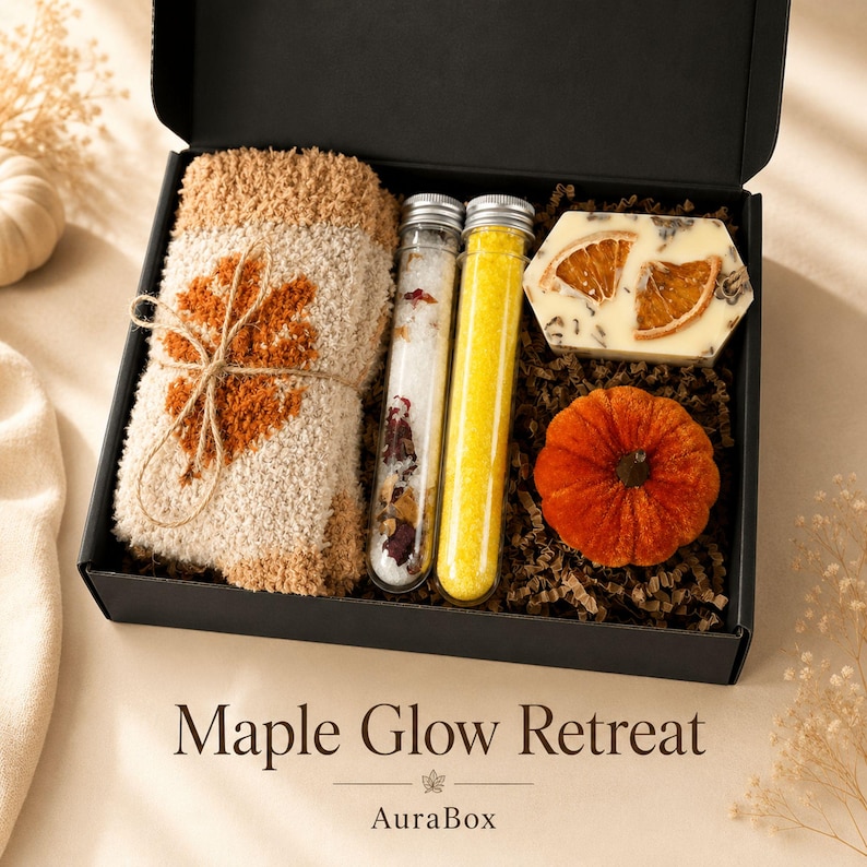 Fall gift box for women featuring a cozy autumn gift basket beautifully arranged in a premium black gift box with pumpkin accent, warm knit socks, sunflower detail, botanical candle, artisan soap and harvest-inspired gifts. Harvest Bliss Box is styled in rich orange, brown, golden yellow and cream fall colors, perfect as a Thanksgiving gift, hostess gift, fall birthday gift, pumpkin care package, autumn gift basket or cozy gift for her.