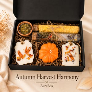 Fall gift box for women featuring a cozy autumn gift basket beautifully arranged in a premium black gift box with pumpkin accent, warm knit socks, sunflower detail, botanical candle, artisan soap and harvest-inspired gifts. Harvest Bliss Box is styled in rich orange, brown, golden yellow and cream fall colors, perfect as a Thanksgiving gift, hostess gift, fall birthday gift, pumpkin care package, autumn gift basket or cozy gift for her.