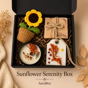 Fall gift box for women featuring a cozy autumn gift basket beautifully arranged in a premium black gift box with pumpkin accent, warm knit socks, sunflower detail, botanical candle, artisan soap and harvest-inspired gifts. Harvest Bliss Box is styled in rich orange, brown, golden yellow and cream fall colors, perfect as a Thanksgiving gift, hostess gift, fall birthday gift, pumpkin care package, autumn gift basket or cozy gift for her.