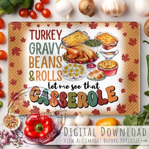 May include: A rectangular cutting board with a Thanksgiving theme. The board features a turkey, casseroles, and the text "TURKEY GRAVY BEANS & ROLLS let me see that CASSEROLE". The background has a pattern of fall leaves.