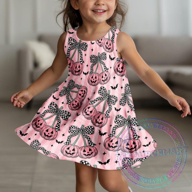 May include: A sleeveless pink dress featuring a Halloween-themed pattern. The dress is adorned with illustrations of pink pumpkins with black and white checkered bows, black bats, and stars. The dress has a flared skirt.