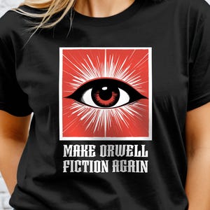 May include: Black t-shirt with a red square featuring a white eye with a red pupil and white rays. The text "Make Orwell Fiction Again" is printed in white below the square.