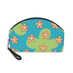 May include: A blue and green cosmetic bag with a pattern of orange flowers. The bag has a black zipper and a black strap.