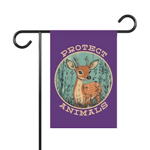 May include: A purple garden flag with a deer illustration inside a circle, surrounded by the text "PROTECT ANIMALS". The deer is brown with white spots and small antlers, set against a backdrop of green foliage.