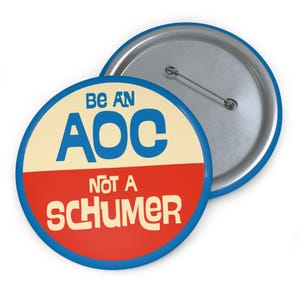 May include: A blue and red button with the text "Be an AOC not a Schumer" in white.