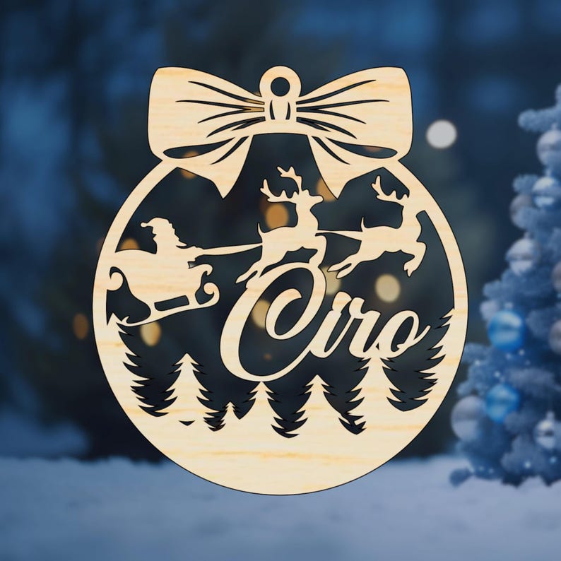 K&ouml;nnte beinhalten: Ein h&ouml;lzerner Weihnachtsbaumschmuck in Form einer Kugel mit einer Schleife oben. Der Schmuck zeigt eine Silhouette des Weihnachtsmanns in einem Schlitten, der von Rentieren gezogen wird, mit dem Wort "Oiro" in einer kursiv geschriebenen Schrift darunter.