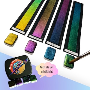 Puede incluir: Un juego de cuatro pastillas de acuarela metálica rectangulares en oro, morado, azul y verde, con muestras de color correspondientes en papel negro etiquetadas Nymphe, Nachtnebel, Sternenfrost y Scarabeus, y una caja de metal negra.