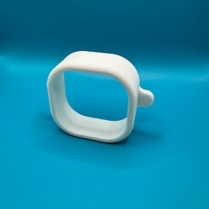 May include: A white plastic ring with a square opening. The ring is designed to hold a round object, such as a bottle or a jar.
