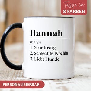 Könnte beinhalten: Weiße Keramiktasse mit schwarzem Henkel und schwarzem Rand. Die Tasse hat schwarzen Text, der "Hannah nomen 1. Sehr lustig 2. Schlechte Köchin 3. Liebt Hunde" lautet. Die Tasse steht auf einer weißen Holzoberfläche. Der Text "Tasse in 8 FARBEN" befindet sich in einem roten Kasten in der oberen rechten Ecke des Bildes. Der Text "PERSONALISIERBAR" befindet sich in einem roten Kasten am unteren Rand des Bildes.