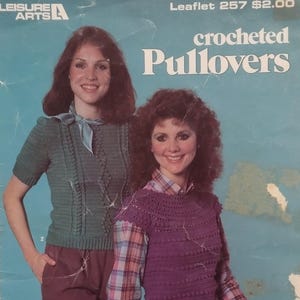 May include: Vintage crochet pattern booklet cover showing two women in crocheted pullovers. The text reads "crocheted Pullovers" and "Designs by Darla". The women are wearing green and purple crocheted tops.