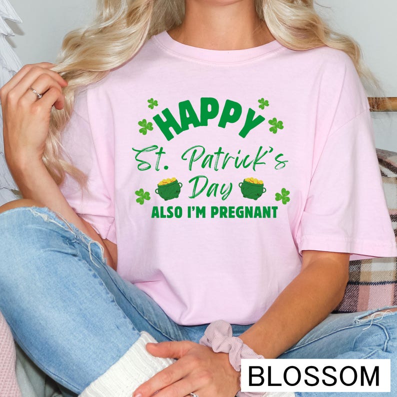 A woman wearing a pink t-shirt with a humorous text related to St. Patrick's Day and pregnancy.