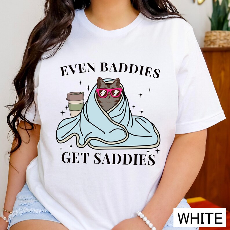 a woman wearing a t - shirt that says even baddies get saddles