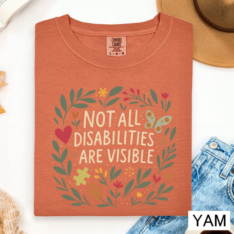 a red t-shirt with a colorful graphic design and text, along with some casual clothing items and a hat.