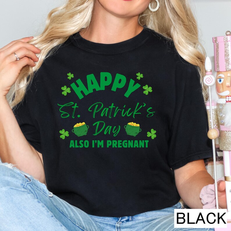 A woman wearing a black t-shirt with a humorous text and graphics related to St. Patrick's Day and pregnancy.