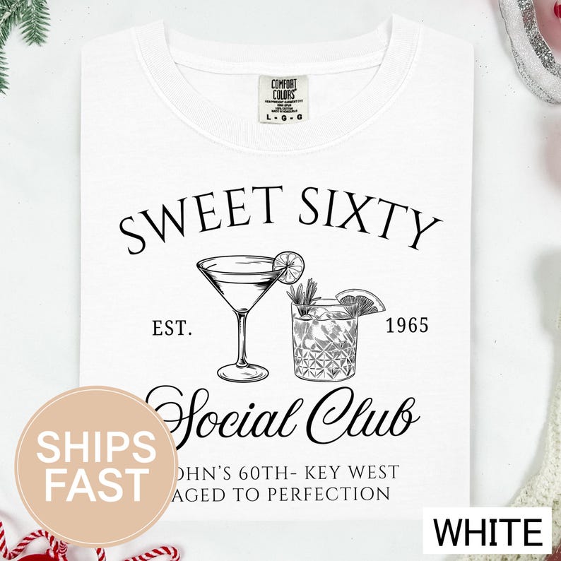 a white t-shirt with a graphic design that includes a cocktail glass and a lemon slice, along with text that reads "Sweet Sixty" and "Social Club".