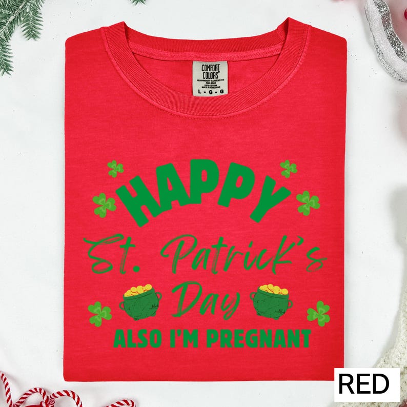 A red t-shirt with a humorous text and graphics related to St. Patrick's Day and pregnancy.