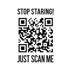 以下が含まれることがあります： 「STOP STARING! 」と「JUST SCAN ME」という黒い文字が書かれた白いステッカー。ステッカーの中央には白黒のQRコードがあります。
