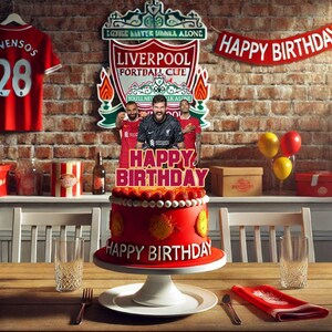 Puede incluir: Un pastel de cumpleaños rojo y amarillo con un adorno del Liverpool Football Club. El pastel está decorado con fresas y las palabras "Happy Birthday" están escritas en el pastel.