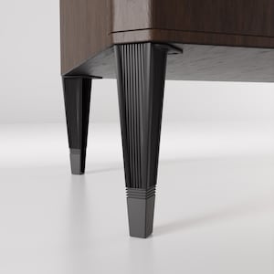 May include: Close-up of a dark wood cabinet with four black legs. The legs have a fluted design and a square base.