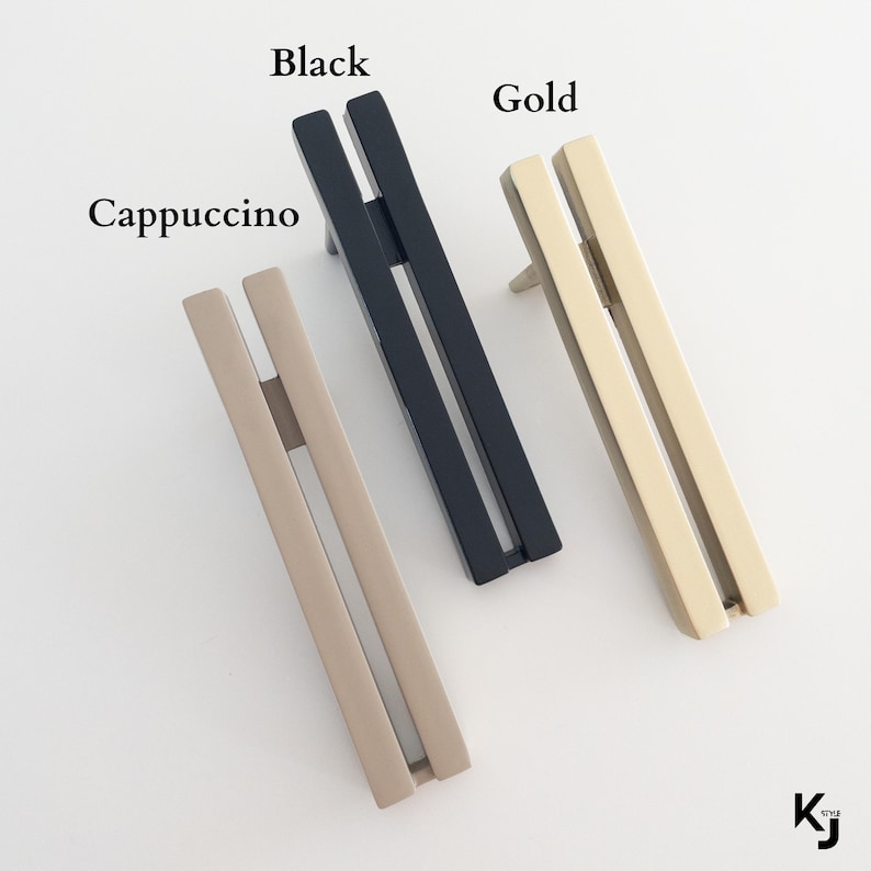 May include: Three cabinet pulls in black, gold, and cappuccino colors. Each pull has a rectangular design with a vertical bar and a horizontal bar. The word "Black", "Gold", and "Cappuccino" are written above each pull.