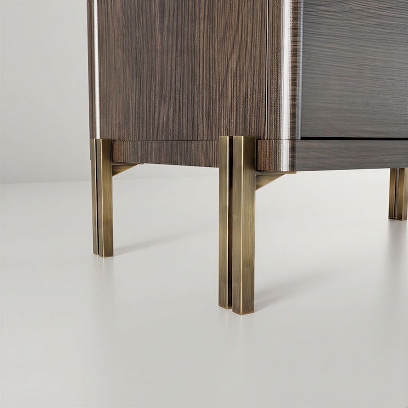 May include: Close-up of a modern wooden cabinet with a dark wood grain finish. The cabinet features brass-colored metal legs. The design is minimalist and elegant, suitable for a living room or bedroom.