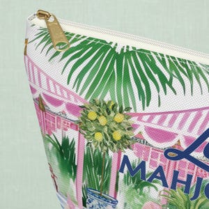 A close-up of a personalizable mahjong zippered tile storage bag highlighting the bag’s fabric texture and gold zipper. The print shows palm leaves and pink stripes on woven canvas.